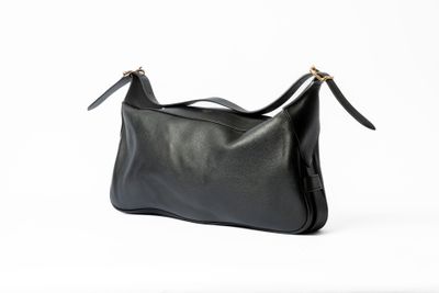 un sac à bandoulière en cuir noir sur fond blanc