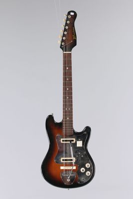 an electric guitar hanging from a string on a wall