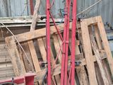 a picture of a pile of wooden pallets and a red crane