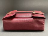 a close up of a red purse on a gray surface