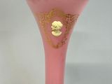 a pink vase with a gold decoration on it