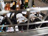 many bottles of wine in a metal basket on the counter