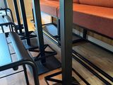 tables and benches in a room with wood floors and a couch