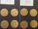 Plusieurs pièces d'or sont présentées sur une surface noire, accompagnées d'une étiquette indiquant leur prix.