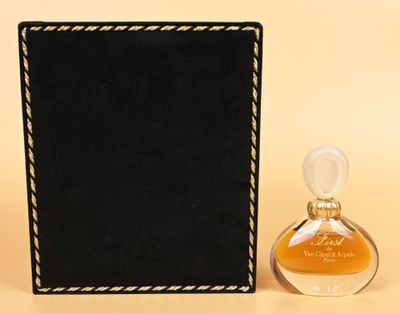 a close up of a bottle of perfume next to a black box