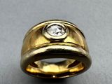 a close up of a gold ring with a diamond in the center