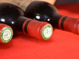 three bottles of wine sitting on a red table