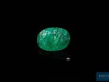a green emerald stone on a black surface