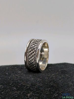 gros plan d'une bague en argent sur une surface noire