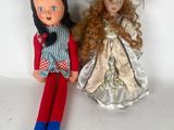 two dolls sitting next to each other on a white surface
