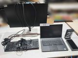 un ordinateur portable et un clavier posés sur une table, à côté d'un écran