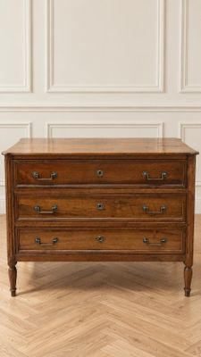 une commode en bois posée sur un parquet dans une pièce
