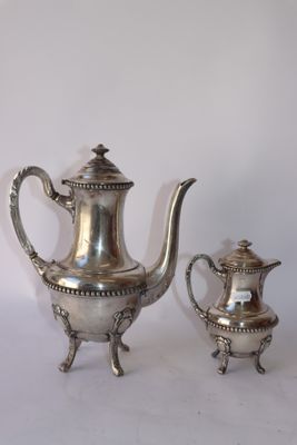 une théière en argent et une autre théière en argent posées sur une table