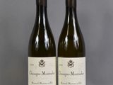 two bottles of wine sitting on top of a table next to each other