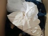 a cardboard box filled with clothes and a blanket