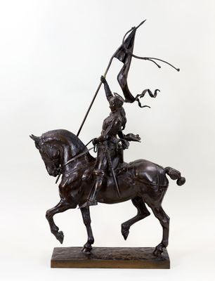 statue en bronze représentant un homme à cheval tenant un drapeau