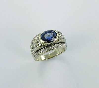 a close up of a ring with a blue stone and diamonds