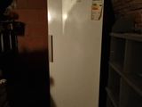 a white refrigerator in a dark room with a brick wall