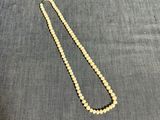 un gros plan d'un collier de perles posé sur un tissu bleu