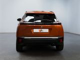 the rear end of an orange suv parked in a white room
