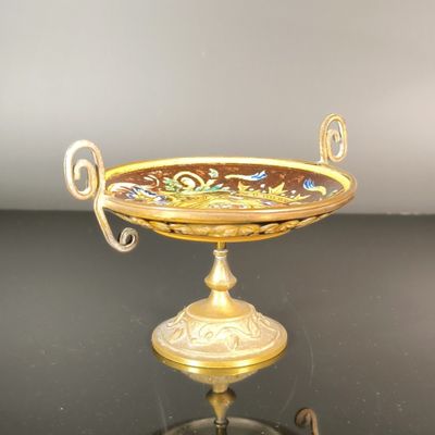 un plateau en or orné d'un motif floral, posé sur un socle