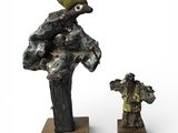 deux sculptures représentant un homme et une femme, posées sur un socle en bois