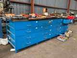 un établi bleu dans un entrepôt, sur lequel sont posés de nombreux outils