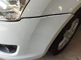 a close up of a white car that has a denting on it
