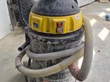 a yellow and black vacuum sitting in a garage