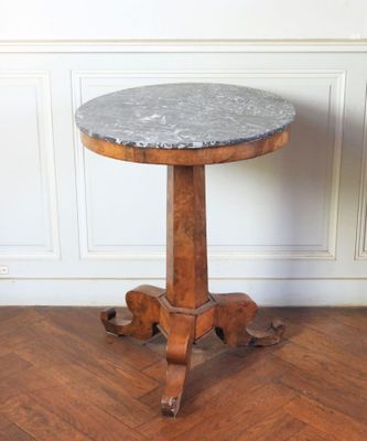 une photo d'une table au plateau en marbre posée sur un parquet