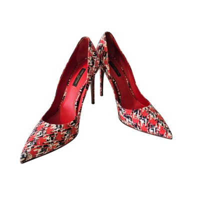 a pair of red and black high heeled shoes on a white background