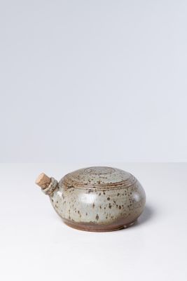 un vase blanc et marron posé sur une table blanche