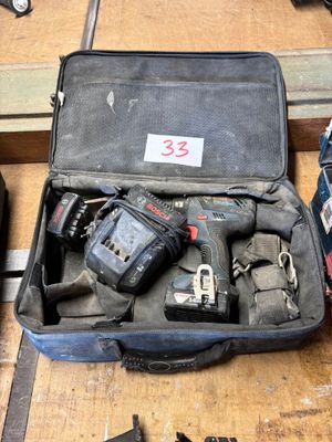 une valise remplie d'outils posée sur un plancher en bois