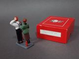 a small figurine of a man standing next to a red box