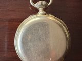 une montre de poche en argent posée sur une table en bois