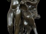 une image représentant une statue en bronze de deux femmes assises sur un rocher