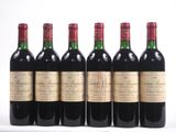 six bouteilles de vin sont alignées sur une surface blanche