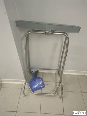 un sac bleu posé par terre à côté d'une étagère en métal