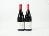 deux bouteilles de vin rouge posées l'une à côté de l'autre sur une surface blanche