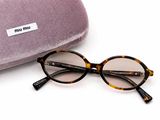 des lunettes de soleil et leur étui posés sur une surface blanche, sur fond blanc