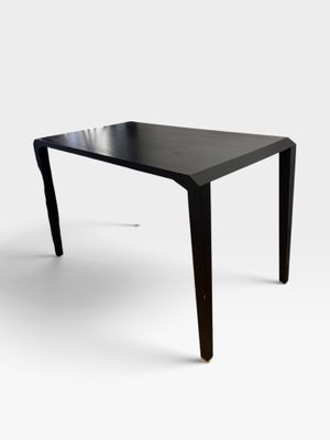 une image représentant une table au plateau noir sur fond blanc