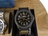 two watches sitting on a table next to each other