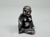 une petite statue représentant un singe assis par terre