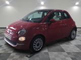 la petite voiture rouge est garée sur un carrelage à carreaux