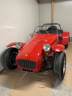 une voiture de sport rouge garée dans un garage, près d'un mur