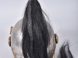 a silver helmet with a long black hair on top of it