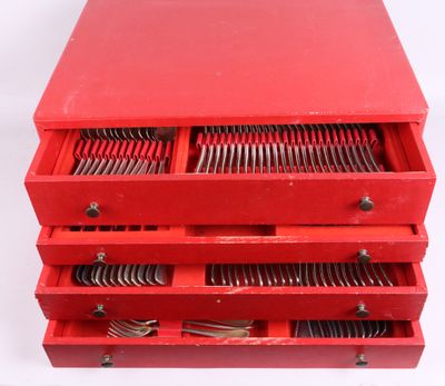 une image représentant un tiroir métallique rouge rempli d'une multitude de couverts