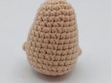 a close up of a crocheted egg sitting on top of a white surface