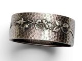 a close up of a silver ring with flowers on it