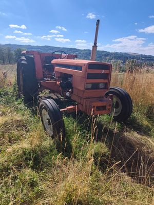 a red tractor that is sitting in the grass